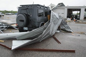 俄克拉荷马州一家汽车经销店的车子遭吹落的铁皮击中。（图：AP）