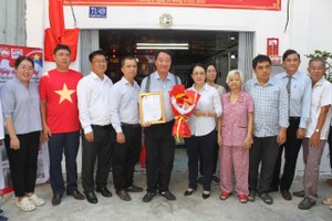 郡、坊领导与庆云南院住持周华邦向黄娥一户移交“温情屋”工程。