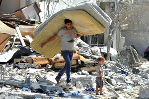 一名巴勒斯坦男子在加沙地带北部被以色列袭击摧毁的房屋废墟中抢救物品。（图：互联网）