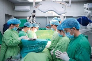 医护团队在器官捐献手术前向捐献者默哀致敬。（图：越通社）