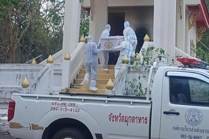 相关人员“全副武装”把棺木抬进焚化炉。（图：互联网）