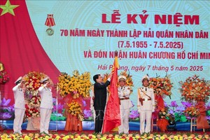 国家主席梁强为越南人民海军传统旗帜上佩挂胡志明勋章。（图：越通社）