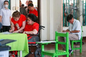 5月12日上午，菲律宾总统小马可斯（右）和他母亲、菲前总统马可斯夫人伊美黛（坐轮椅），在北伊罗戈省一投票站投票。（图：AFP）