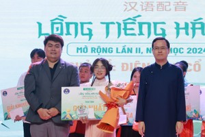 中国驻胡志明市总领事馆副总领事徐州（右）与文献大学外语系中文专业主任阮进长安老师向赢得汉语配音冠军颁奖。