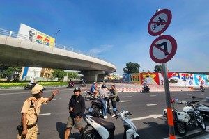 执勤交警截停一名违规骑士，并向其提醒、指引正确的行驶方向。（图：越通社）