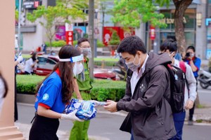 市卫生厅表示，Omicron XEC并不是新冠病毒的新变异株，但仍需加强监控。图为一名女性志愿者向路人免费派发口罩。（示意图：黄英）