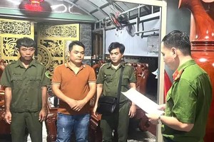 调查机关在阮伯清（中）住所执行搜查令。