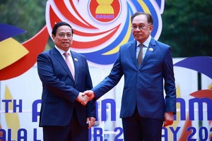 马来西亚总理安瓦尔·易卜拉欣迎接越南政府总理范明政。(图：越通社)