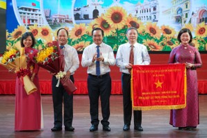 市人委会主席阮文得向第一郡干部与人民颁发政府的竞赛旗帜。