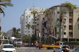 特拉维夫利维·埃什科尔路（Levy Eshkol）的一栋公寓楼在6月16日凌晨被导弹击中后被摧毁。（图：越通社）