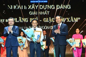 市委书记阮文年与市委常务副书记阮青毅给《西贡解放报》记者组代表颁发党建设新闻类的一等奖。