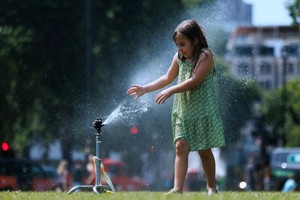 一名女孩把水喷洒到脸上解暑。（示意图：互联网）