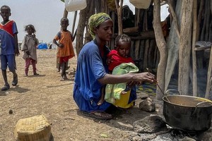 埃塞俄比亚阿法尔，一位流离失所的母亲为家人做饭。（图：联合国）