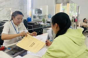 一名公务员正在为市民办理行政手续。（图：潘英）