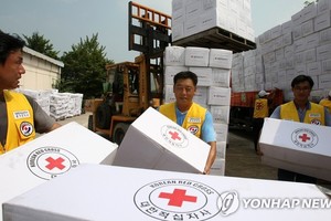 韩国红十字会志愿者搬运对朝人道援助物资，摄于2007年。（图：韩联社）