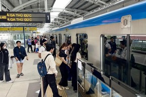 人们在地铁1号线守德站登上列车。（示意图：周俊）