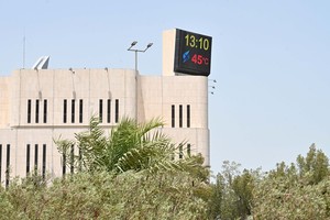 在科威特首都科威特城一栋建筑顶部的萤幕上显示出即时气温。（图：新华社）