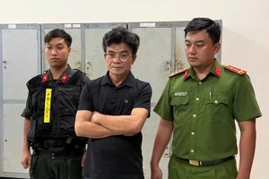 嫌犯武成心（中）在听取执法警员宣读拘捕令。（图：警方提供）