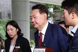 7月5日，在位于首尔瑞草区的首尔高等检察厅，韩国前总统尹锡悦（居中）到案接受内乱叛国案独检组第二次调查。（图：韩联社）