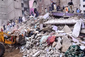 7月4日，在巴基斯坦南部港口城市卡拉奇，救援人员在住宅楼废墟中开展搜救工作。（图：新华社） 