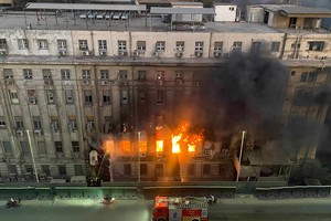 消防人员在埃及首都开罗一座电信大楼的火灾现场工作。（图：新华社）