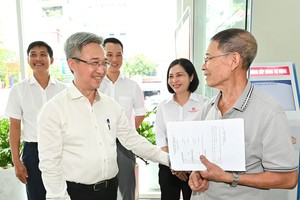 市委副书记邓明通与办理行政手续的平征坊民众交谈。