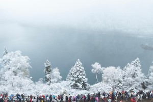 图为游客在九寨沟长海欣赏雪景（10月24日摄，无人机照片）。 （图：新华社）