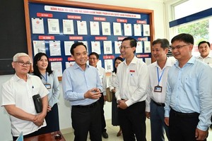 胡志明市市委书记陈留光与工作团考察苡安坊公共行政服务中心的运作情况。