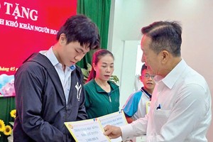 市华文教育辅助会主席古家寿颁发奖助学金给贫困子弟。