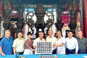 穗城会馆理事会特邀着名书画家黄献平，为天后庙模糊不清的诗句字迹进行修补。