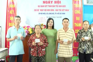 Bà Nguyễn Thị Ngọc Liên, Phó Chủ tịch Ủy ban MTTQ Việt Nam xã, Chủ tịch Hội LHPN xã Long Hải trao thẻ BHYT cho hộ khó khăn tại Ngày hội Đại đoàn kết toàn dân tộc năm 2025 ở ấp Hải Hòa