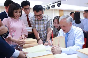 GS-TS Nguyễn Hòa Bình, nguyên Phó Thủ tướng Thường trực Chính phủ ký tặng sách cho bạn đọc. Ảnh: NGUYỄN CHẮT