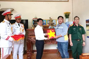 Đồng chí Bùi Chí Thành, Ủy viên Ban Thường vụ Thành ủy TPHCM, Bí thư Đảng ủy, Chủ tịch HĐND phường Phú Mỹ trao di ảnh cho thân nhân liệt sĩ