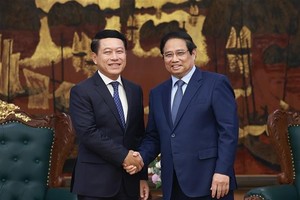 政府总理范明政与老挝副总理、人民革命党中央企业改革委员会主任沙伦塞•贡马西合影。图自越通社。