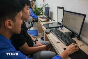 志愿共青团团员指导群众在线申报为子女办理出生证书。图自越通社