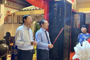 胡志明市人委会主席阮文得(右)和市人委会常务副主任阮文寿向左军黎文悦灵位上香。