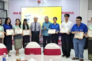 老挝人民民主共和国驻胡志明市总领事蓬西·本米塞（右起第五位）与胡志明市各友好组织联合会代表向获奖大学生颁奖。