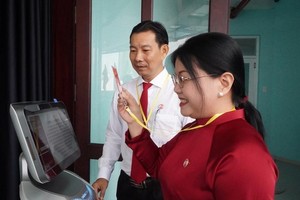 出席和兴坊党部大会的代表使用机器人点名报到。