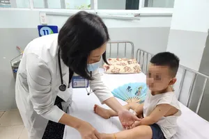 胡志明市第一儿童医院医生为手足口病患儿诊治。