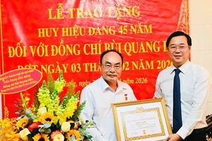 胡志明市市委常务副书记黎国峰向裴光边上将颁授45年党龄纪念章《决定》。