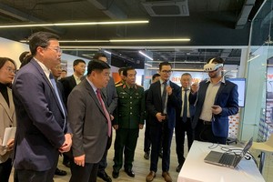 越南副总理阮志勇和其他代表听取了关于人工智能与数字孪生研发中心及卓越中心的报告。图自qdnd.vn