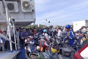 丙午年大年初二，市民与游客在胡志明市东面区域等候渡轮出行。