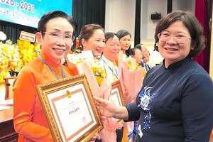 胡志明市市委副书记文氏白雪向联合会成员单位和个人颁发市人委会的奖状。