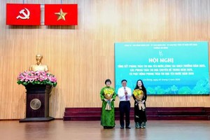 胡志明市人委会副主席阮孟强向安东坊党委书记张明娇（左）和安东坊人委会主席阮氏明凤献花祝贺。