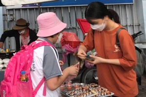  胡志明市一学校门口摆卖的食品车摊。