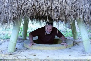 外国游客体验奇英地道当地居民院子里的地道口。