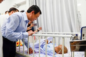 卫生部副部长阮知识率领工作团探望遭受虐待的2岁男童。