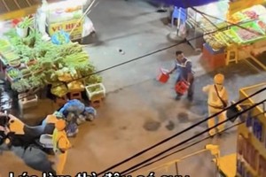  一名男子手持塑料凳与两名交警争执。图：视频截图