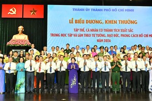  胡志明市领导与荣获表彰的集体、个人代表合影。图：越勇