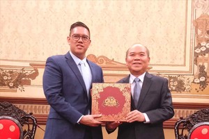 胡志明市人委会副主席陈文柒向印尼国会安全、国防、外交与情报委员会（第一委员会）副主席戴夫·阿克巴沙·菲卡诺·拉克索诺赠送纪念品。图：明珠